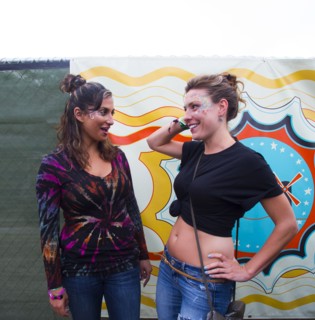 Women talking near multicolor mural