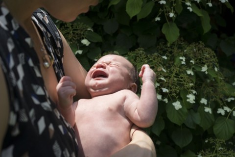 Mother holding crying baby in arms