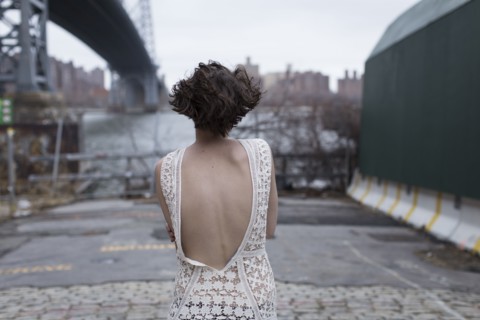 Woman in low-back dress walking in industrial area