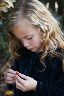 Close up of girl examining berry outdoors