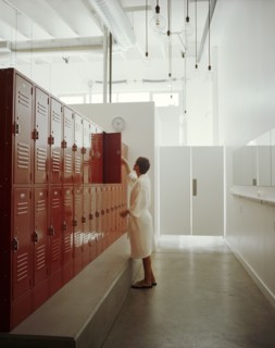 Woman opening locker in locker room