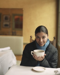 Indian woman drinking coffee in cafe
