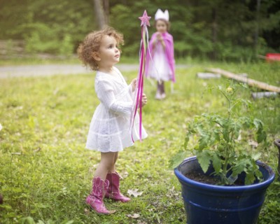 Girl playing with wand in backyard garden