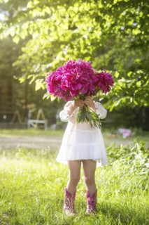 Girl holding bouquet of flowers in backyard