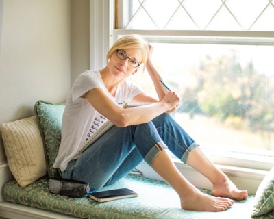 Caucasian woman sitting in windowsill