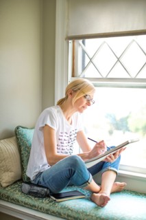 Caucasian woman drawing in windowsill