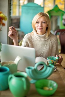Caucasian entrepreneur using laptop in shop
