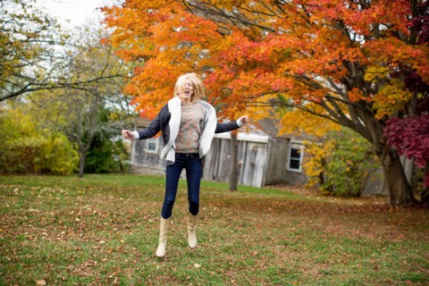 Caucasian woman jumping for joy in backyard