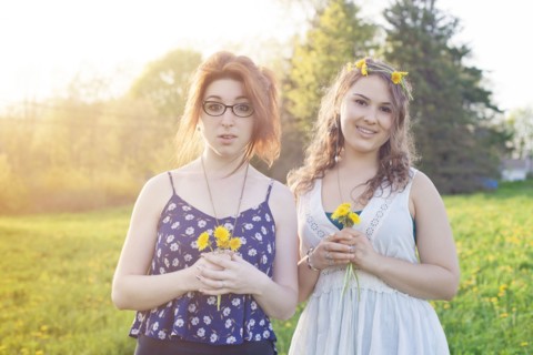 Caucasian women holding flowers in field