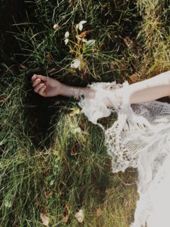Bride wearing wedding dress in tall grass