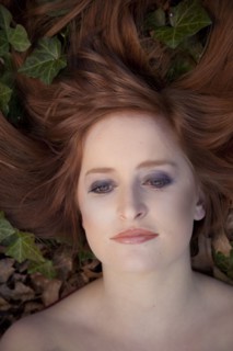 Close up of serious Caucasian woman laying in leaves