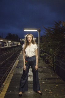 Woman waiting for train at train station at night