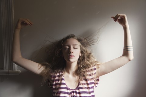 Woman playing with her hair in sunlight