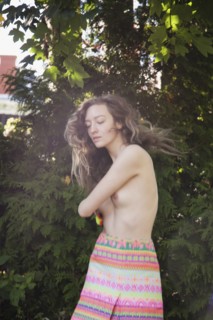 Topless woman dancing in garden