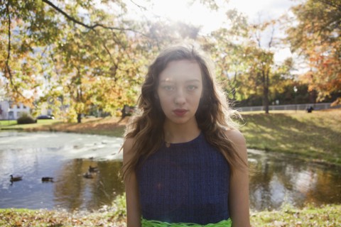 Woman standing near duck pond in park