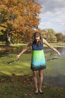 Woman wearing dress near duck pond in park