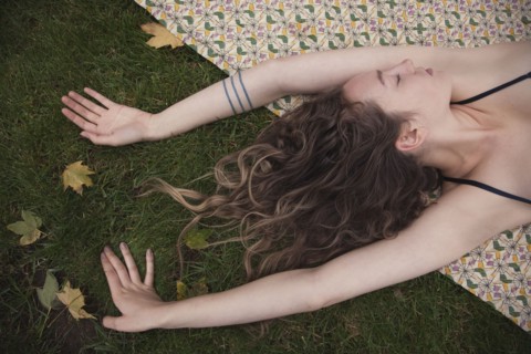 Woman laying on blanket in grass