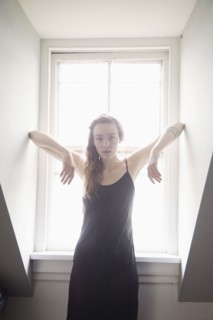 Woman standing at sunny window
