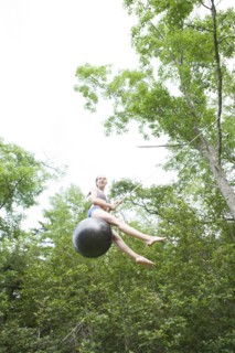 Teenage girl swinging on rope swing