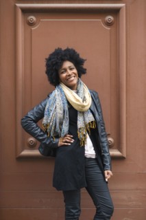 Black woman smiling near frame in wall
