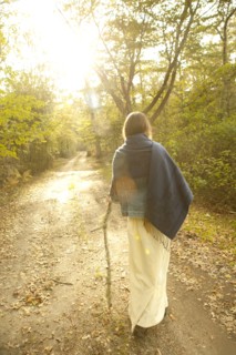 Woman walking on dirt path in forest