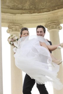 Caucasian groom carrying bride after wedding