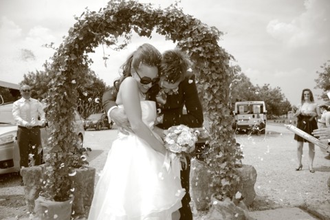 Caucasian bride and groom walking through archway