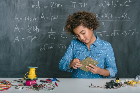Mixed race student building vehicle in science class