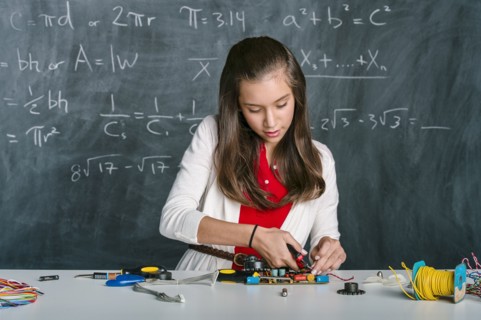 Hispanic student building vehicle in science class