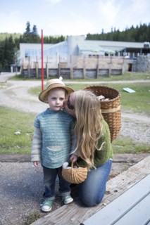 Mother with long hair kissing son in park