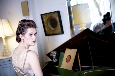 Woman sitting at piano in ornate living room