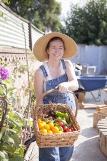 Mixed race farmer gathering produce in garden