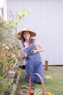Mixed race farmer gathering vegetables in garden