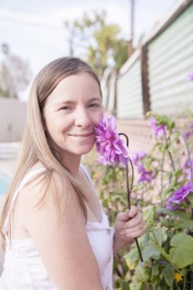 Mixed race woman smelling flowers in garden