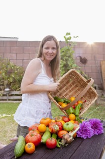 Mixed race woman with basket of vegetables and flowers