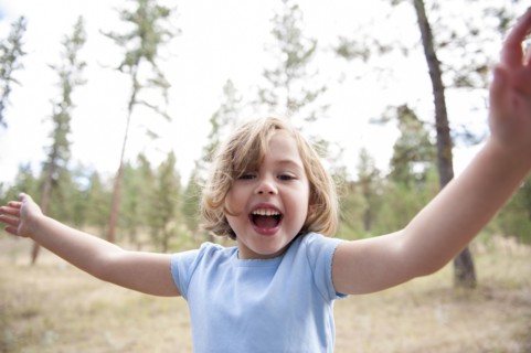 Close up of smiling Caucasian girl in forest