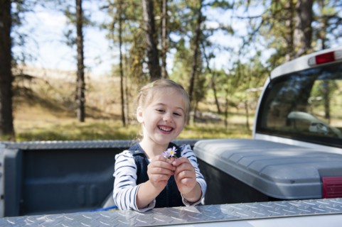Caucasian girl playing in truck bed