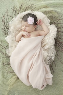 Caucasian baby girl laying in nest