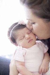Caucasian mother kissing baby girl