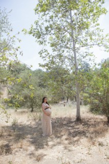 Pregnant Caucasian woman standing in forest
