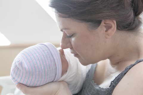 Caucasian mother rubbing noses with newborn daughter