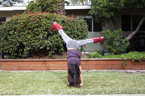 Mixed race girl doing cartwheels in backyard