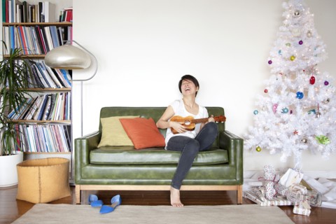 Japanese woman playing ukulele near Christmas tree