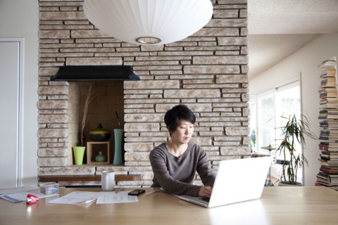 Japanese woman paying bills on laptop