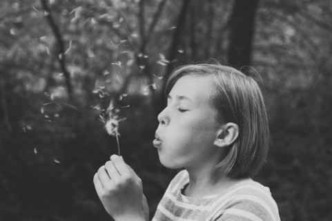 Girl blowing dandelion seeds