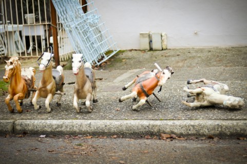Toy rocking horses on city sidewalk