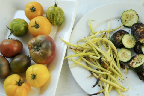 Plates of fresh tomatoes and grilled vegetables