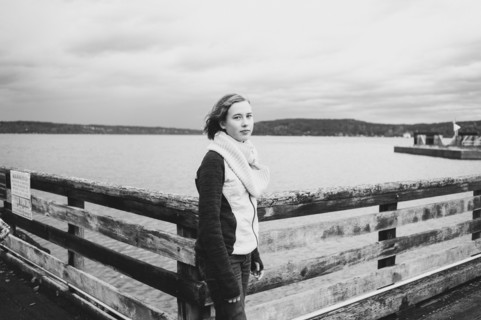 Girl standing on wooden dock at lake