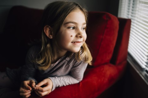 Smiling girl sitting in armchair