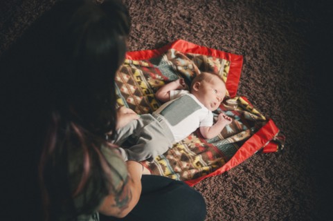 Mother playing with baby daughter on blanket